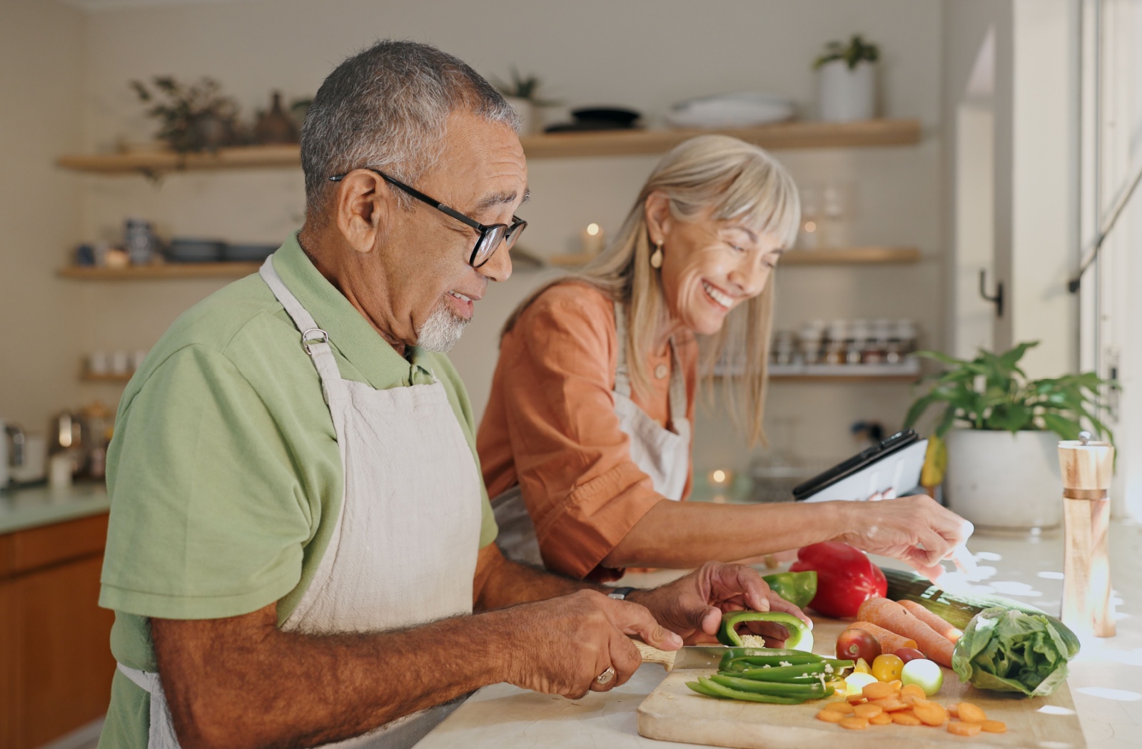 A happy senior couple spends an afternoon meal prepping together.