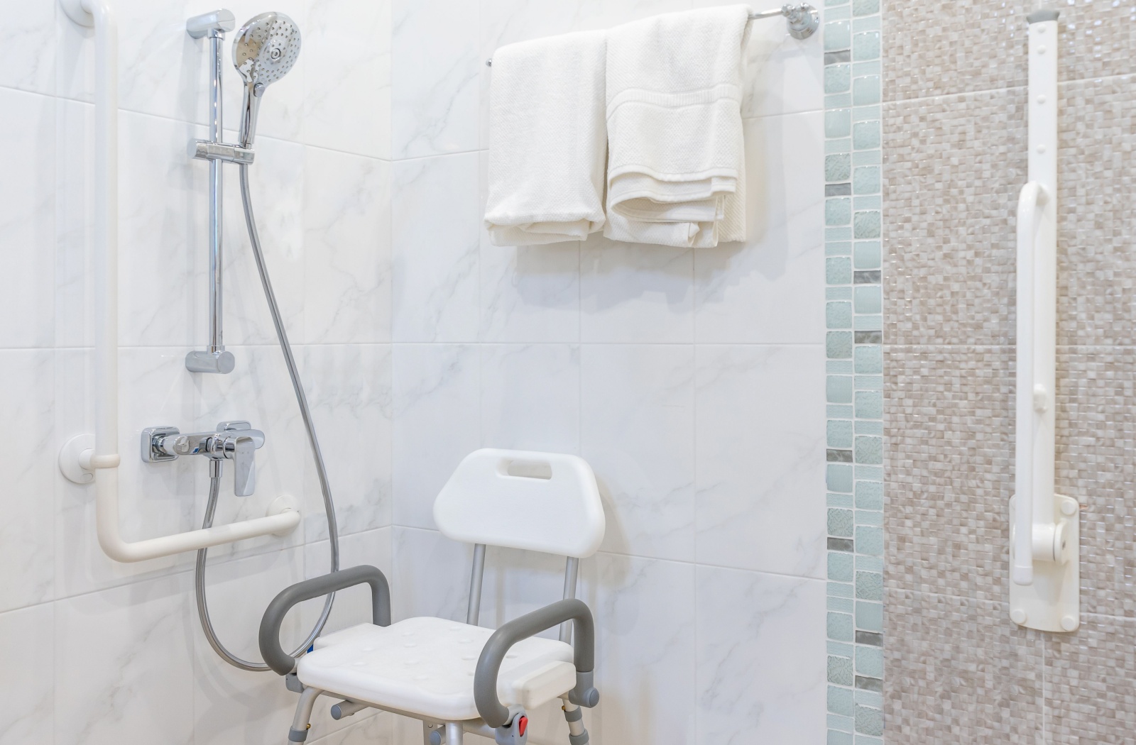 A picture of a senior-friendly shower with various supports in it.