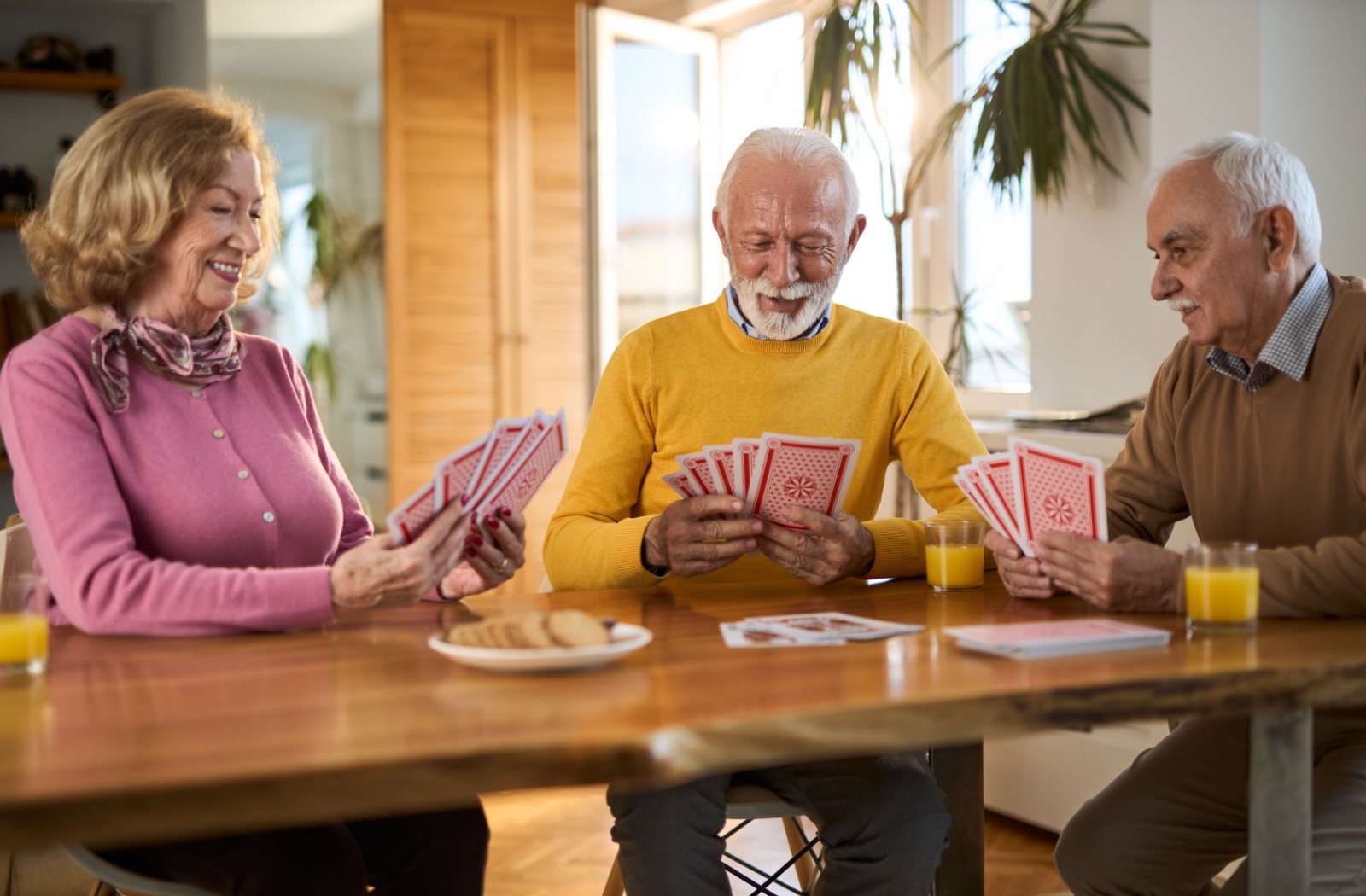 A group of older adults enjoying a card game in senior living.