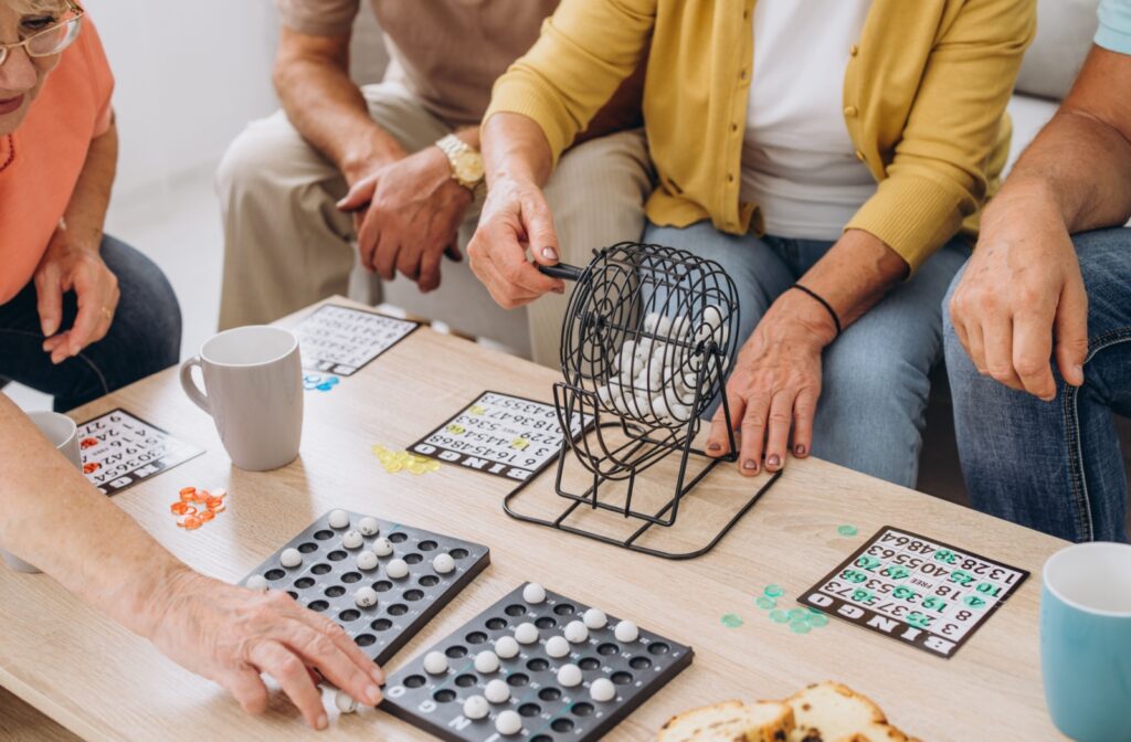 A close-up view of older adults playing bingo on a table.