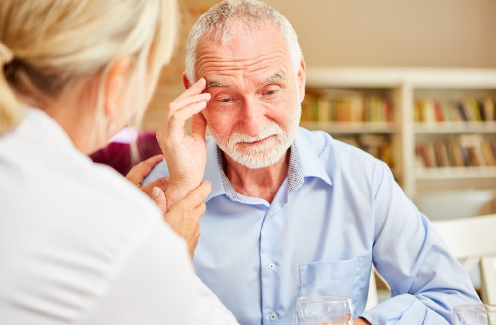 A doctor examining an older adult man who is experiencing disorientation and confusion.