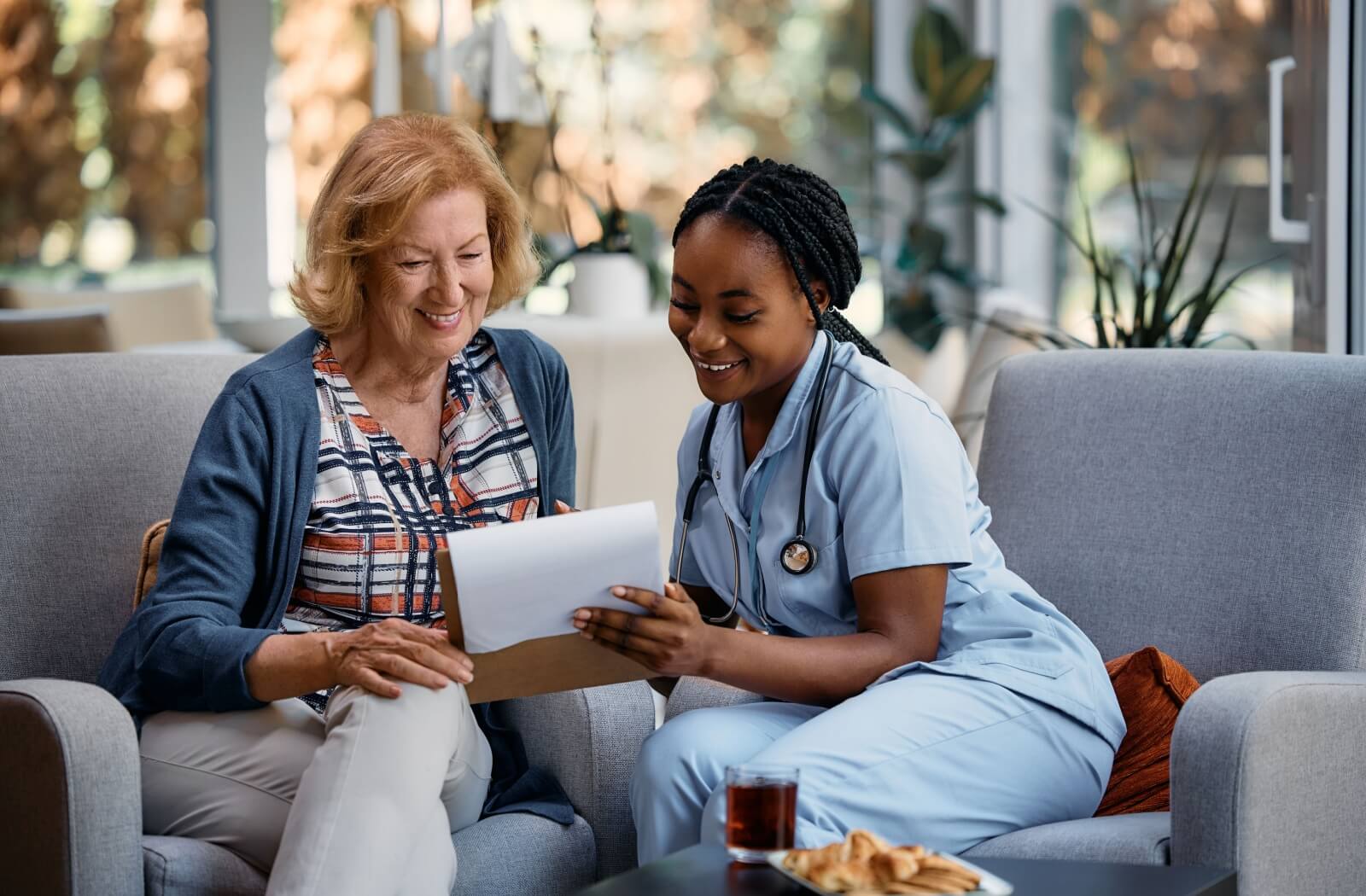 An older adult going through paperwork with a staff member in assisted living.
